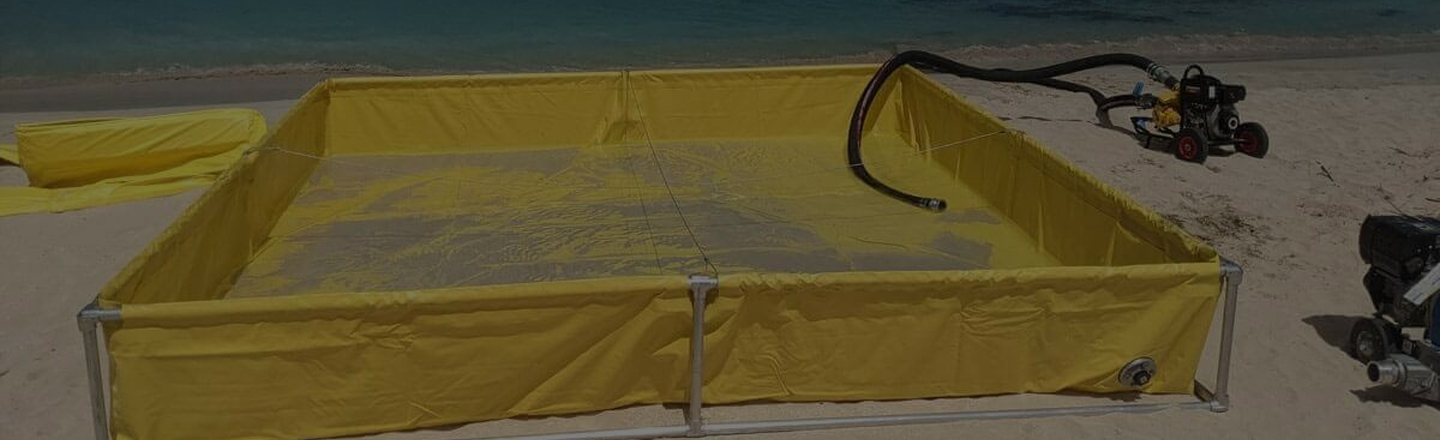 Portable spill containment tank on sandy shore