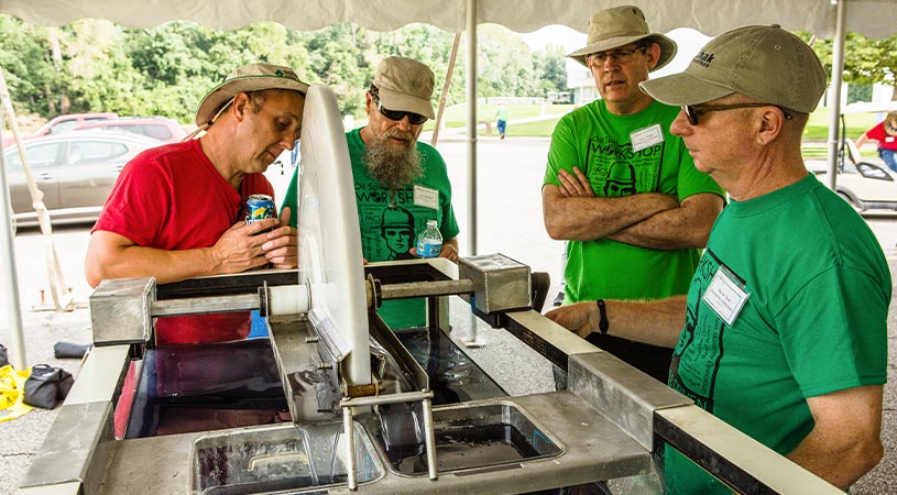 group of men observing oil skimmer